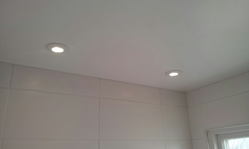 Montering av ledspotlights vid badrumsrenovering.
